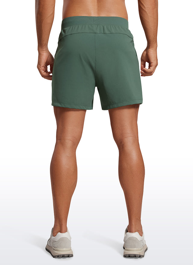 CRZ YOGA Men's Train Relaxed Fit On the Travel Linerless Shorts 5'' Dark Forest Green